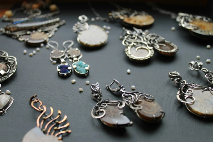 a table topped with lots of different types of necklaces